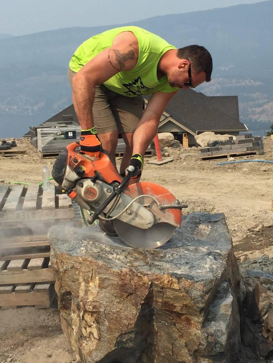 Erik Jonson using a saw to cut stone